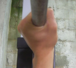 Долоні стиснуті на грифі в кулак, великий палець спрямований вперед